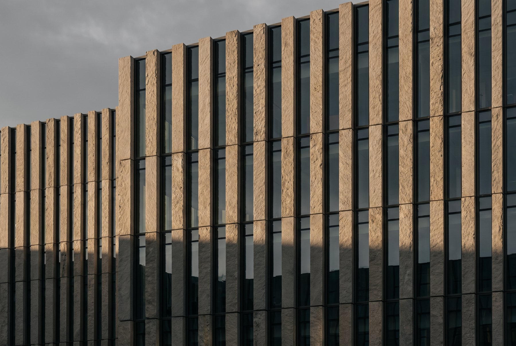 Stone fins and dark glass on a modernist facade