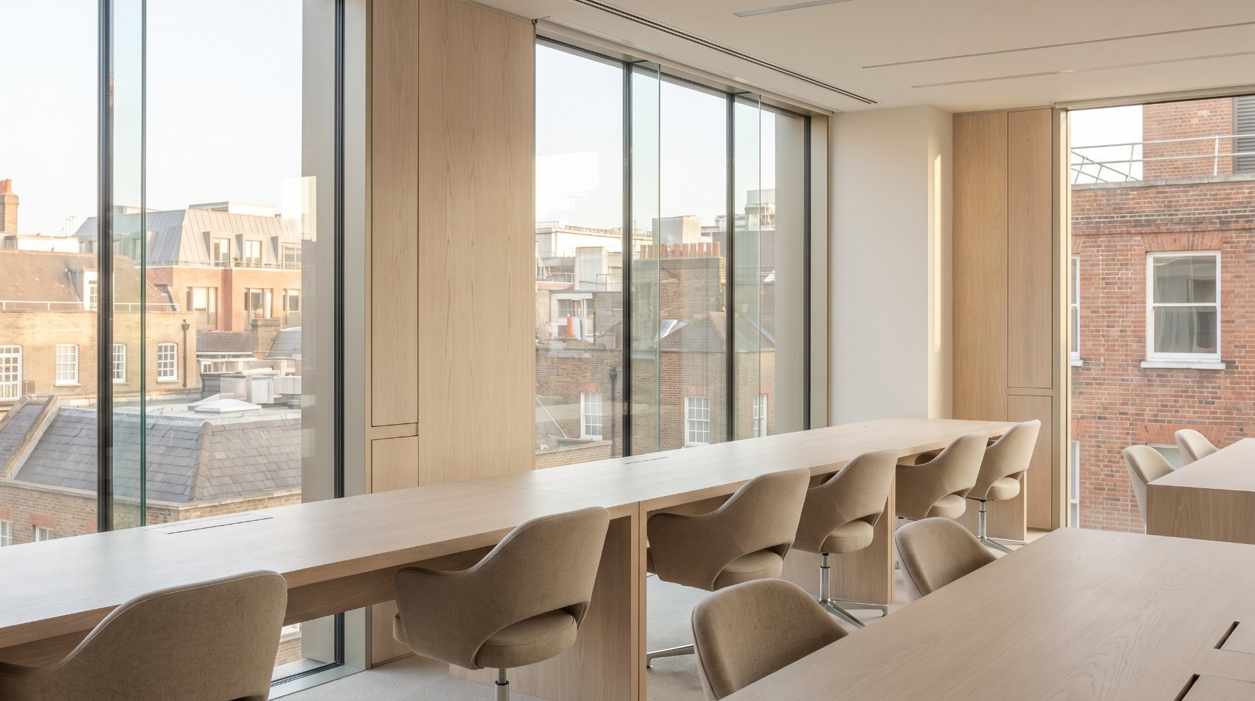 Empty investment office desks beside tall windows